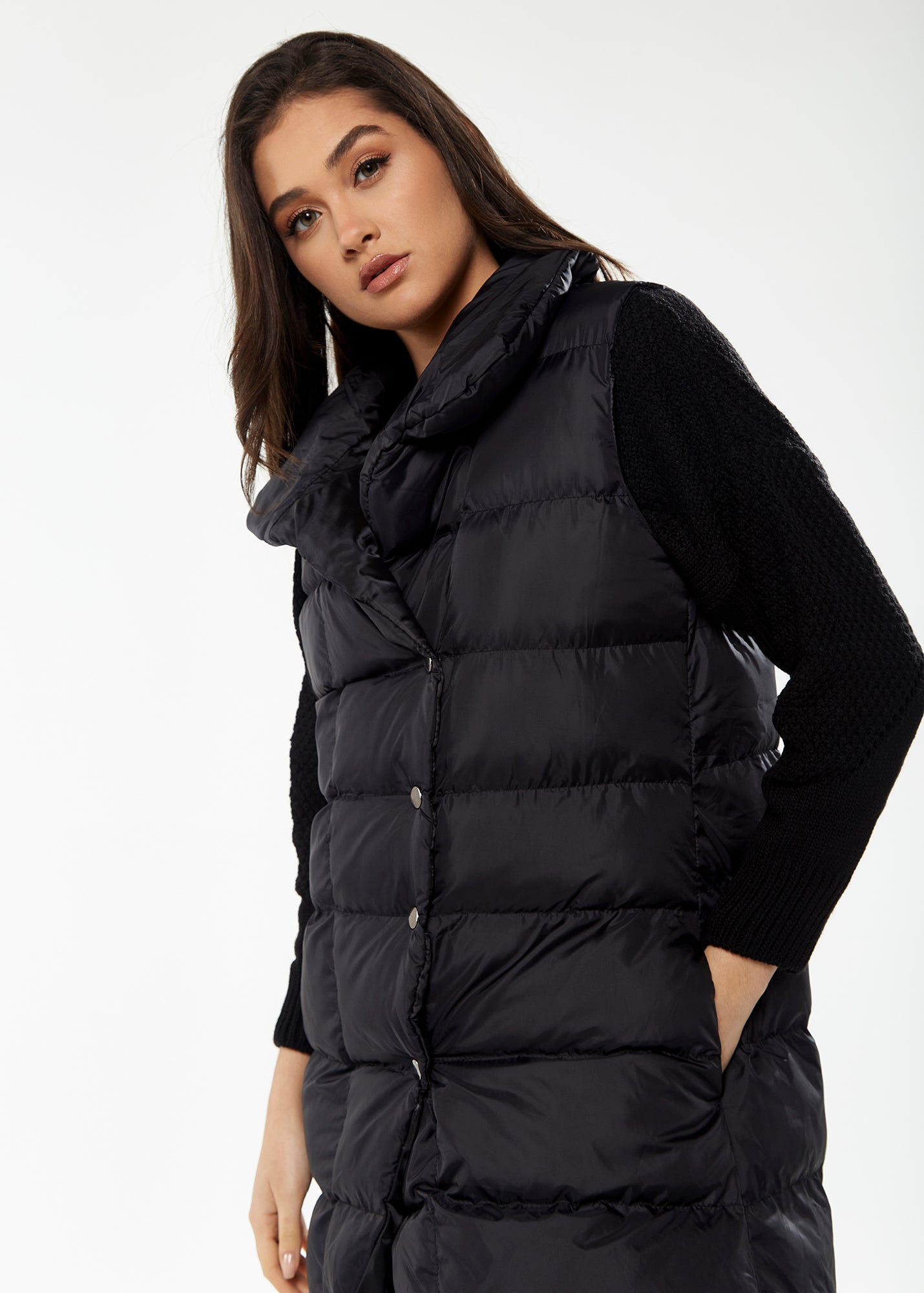 
                  
                    Women's Long Black Puffer Gilet with Asymmetric Button Closure, Drawstring High Neck, and Side Pockets for Ultimate Warmth
                  
                